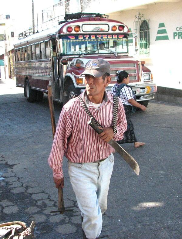 Laborer, Santiago Atitlan, with "chicken bus" in background
